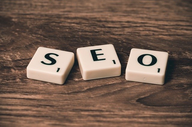 Trei piese de joc din plastic care formează acronimul SEO pe o masă din lemn texturată. optimizat pentru SEO. optimized for seo