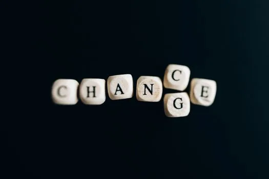 Piese cu litere pe fundal negru care transformă cuvântul CHANGE în CHANCE, simbolizând oportunitățile unui proces de rebranding.