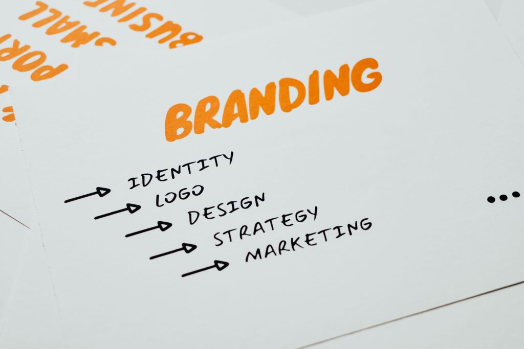 Close-up of a paper with branding, identity, design, strategy, and marketing concepts in orange and black.
