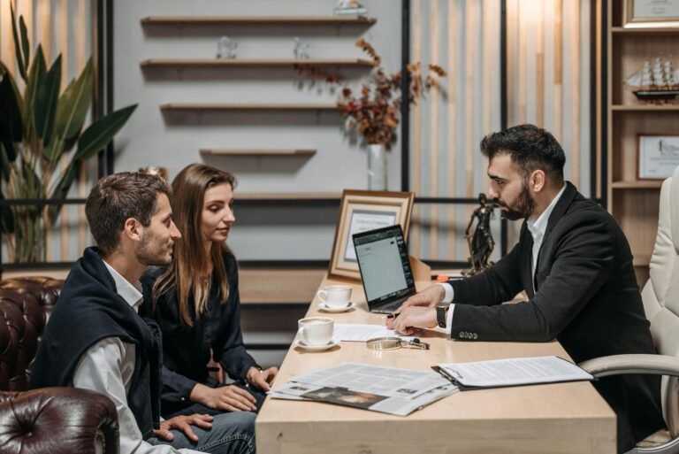 Un cuplu discutând cu un consultant la birou despre implementarea unui nou proiect de website design.