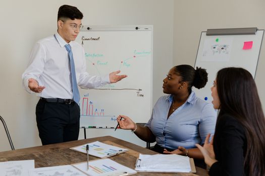 A diverse team discussing business strategies during a meeting with charts.