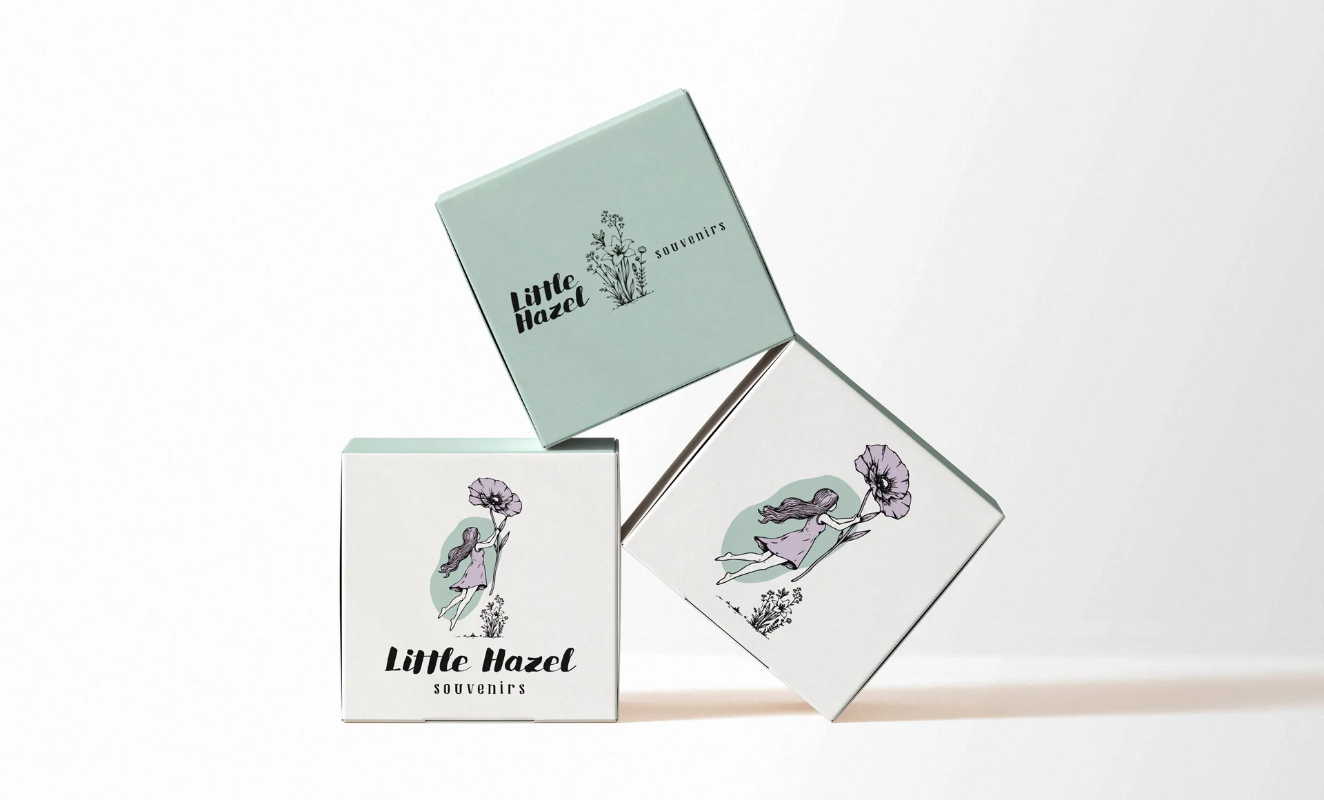 Trei cutii pătrate de ambalaj din carton, în nuanțe de alb și verde mentă, personalizate cu logo-ul și ilustrațiile botanice Little Hazel Souvenirs, realizate de FloBold. Brand Identity souvenirs.
